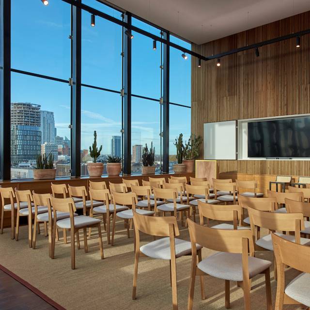 A conference room featuring wooden chairs and a large window allowing natural light to illuminate the space.
