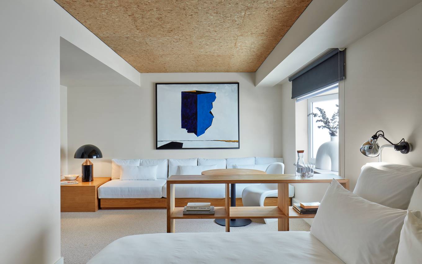 Modern suite at One Hundred Shoreditch with cosy seating, contemporary art, and ample natural light.