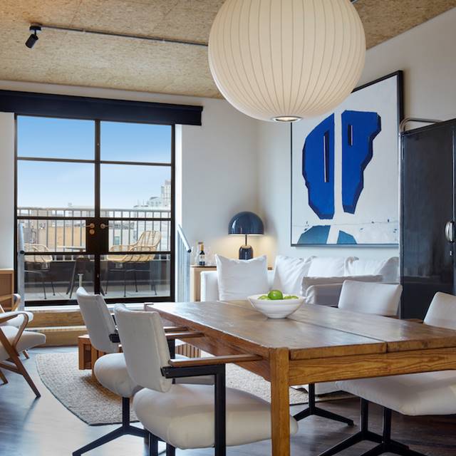 A modern living room featuring a table surrounded by chairs, creating an inviting space for gatherings and relaxation.