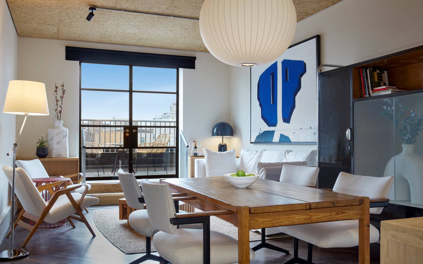 A modern living room featuring a table surrounded by chairs, creating an inviting space for gatherings and relaxation.