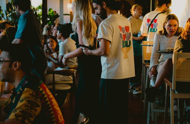 People seated at tables in a restaurant, enjoying their meals and engaging in conversation.