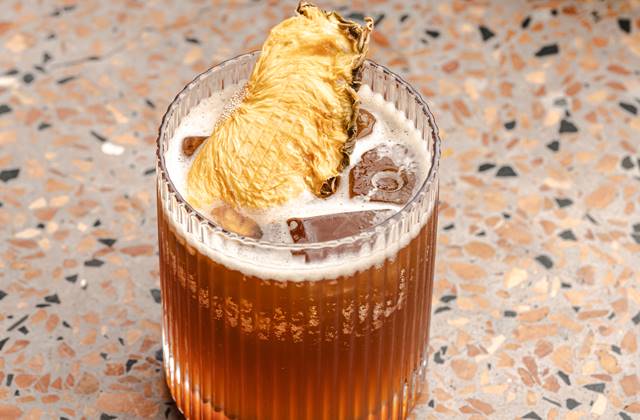 A refreshing drink garnished with a vibrant pineapple slice, showcasing a tropical and inviting presentation.