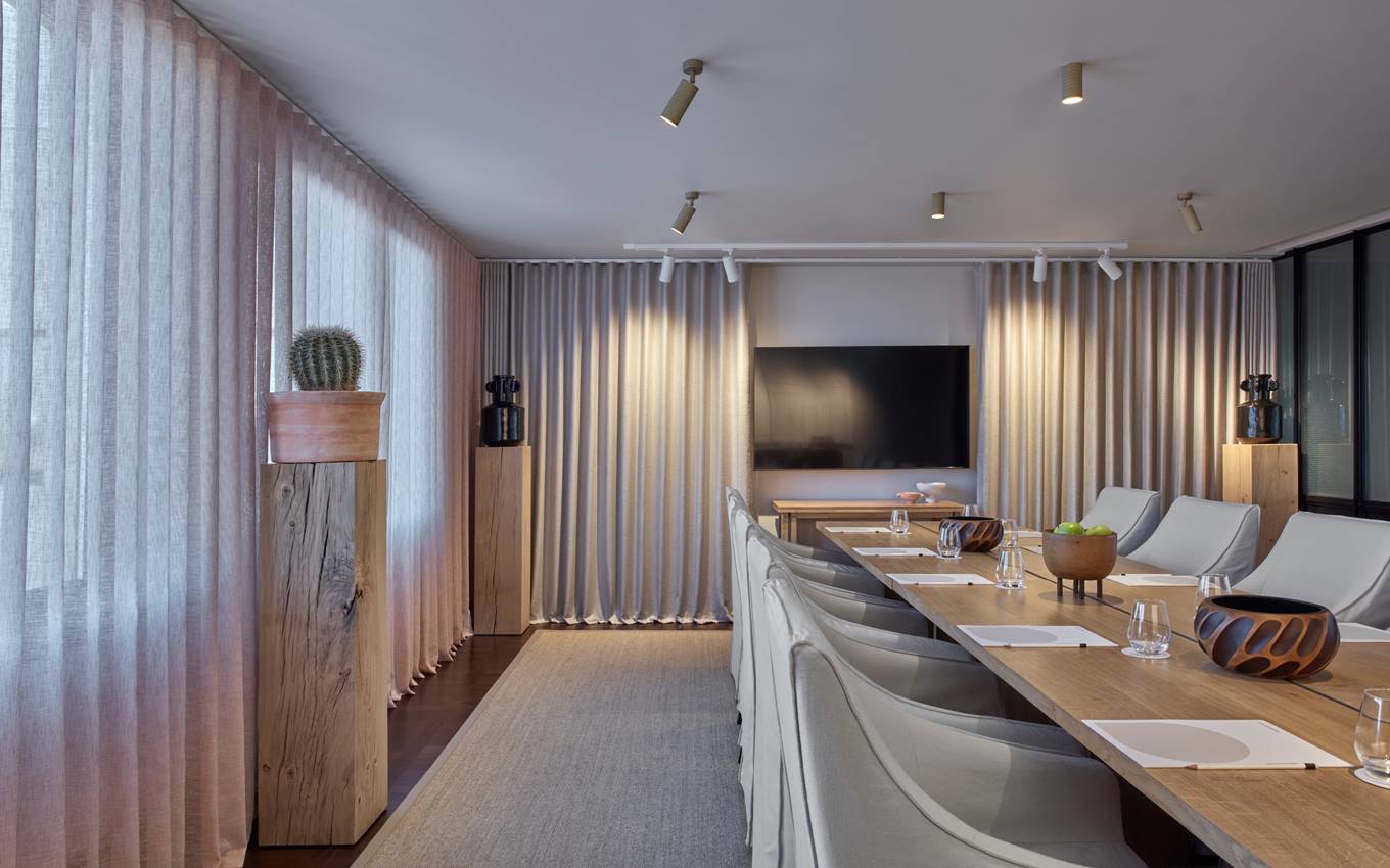 A conference room featuring a long table surrounded by chairs, designed for meetings and discussions.