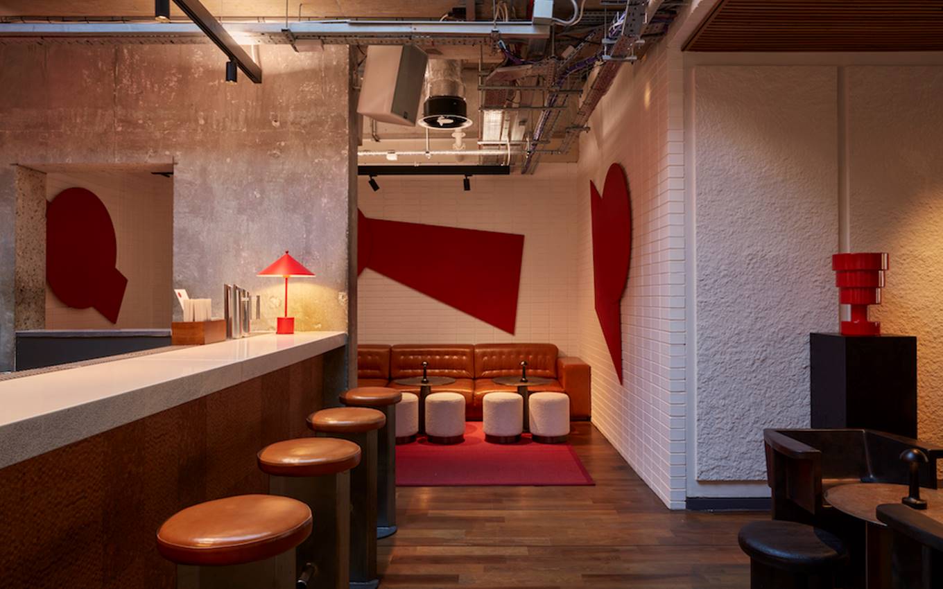 A bar featuring red and white walls, complemented by stylish stools for a vibrant and inviting atmosphere.