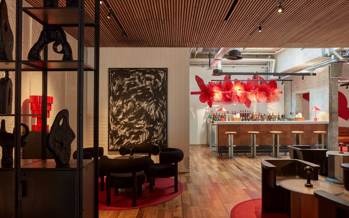 A contemporary bar featuring striking red and black artwork adorning the walls, creating a vibrant atmosphere.