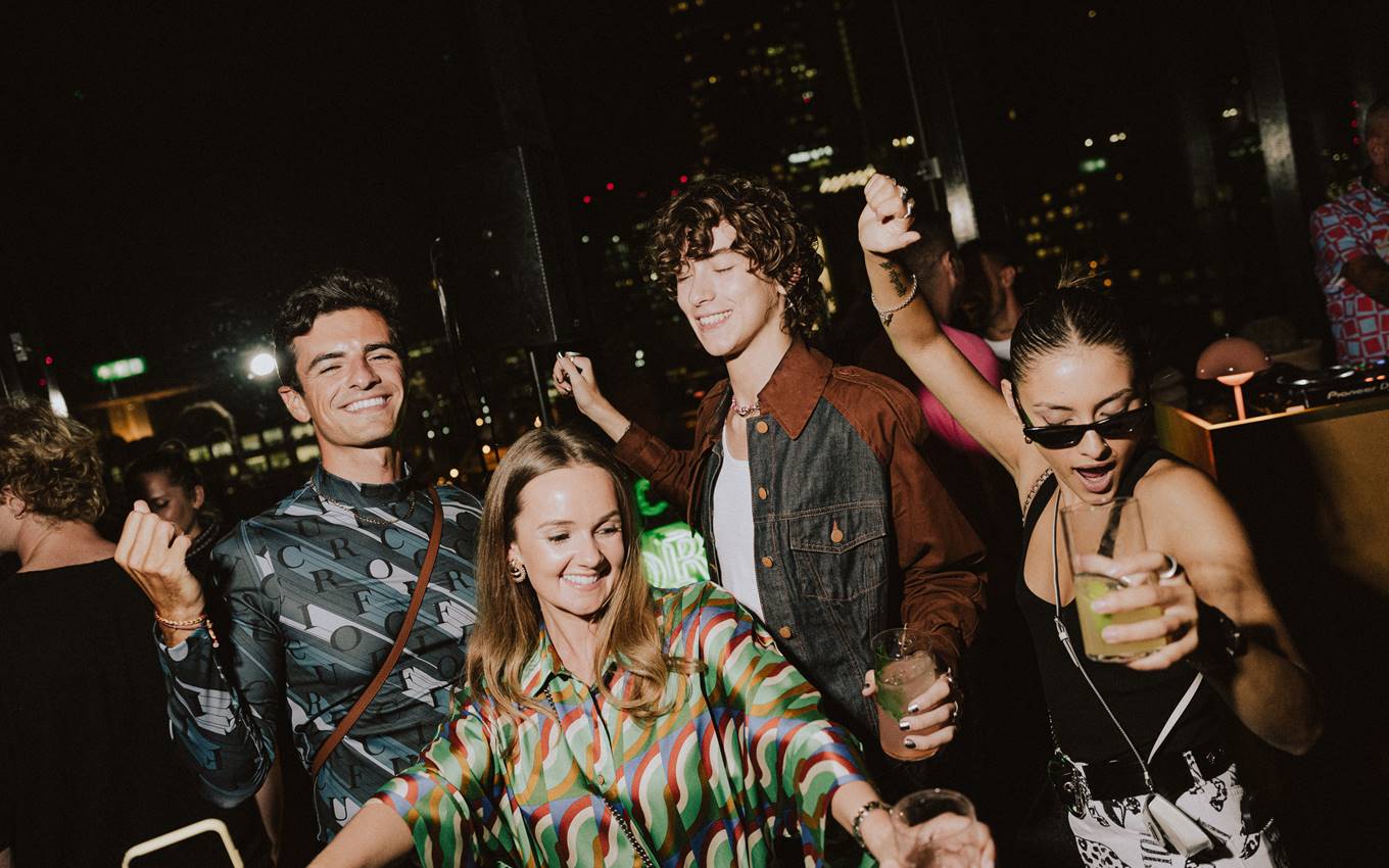 A lively gathering of people enjoying drinks and conversation at a festive party atmosphere.