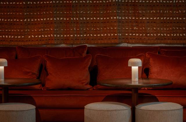 An inviting bar scene featuring plush velvet seating, creating a lively ambiance for social gatherings.